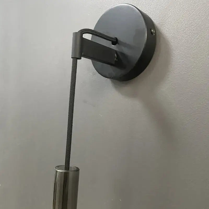 Black decorbites led glass wall lamp with cylindrical metallic stem and circular base for modern indoor lighting