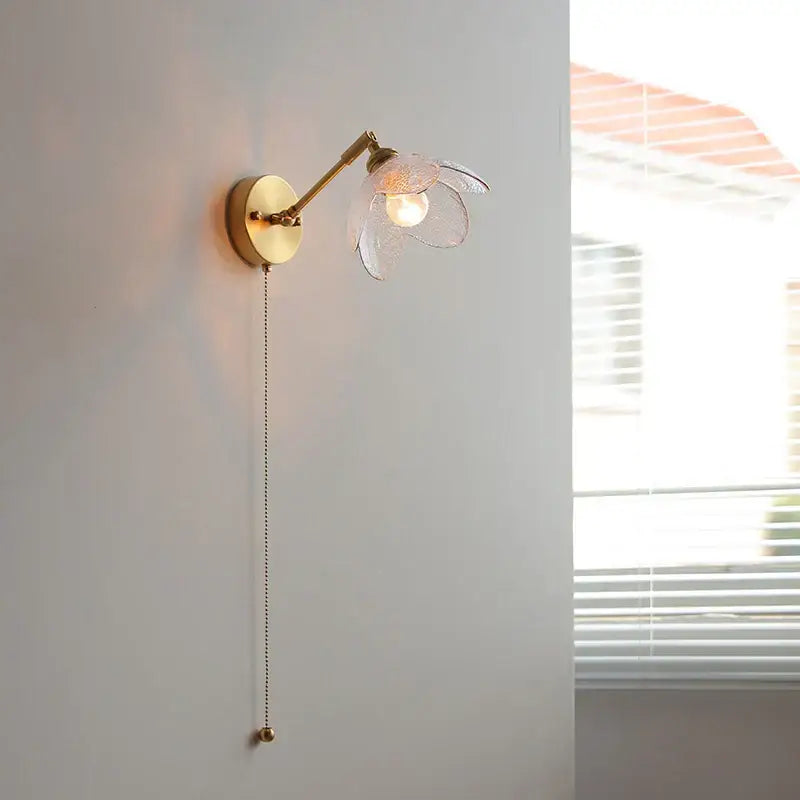 Gold-toned DecorBites™ LED glass wall light fixture with translucent flower shade and adjustable arm for modern living room use