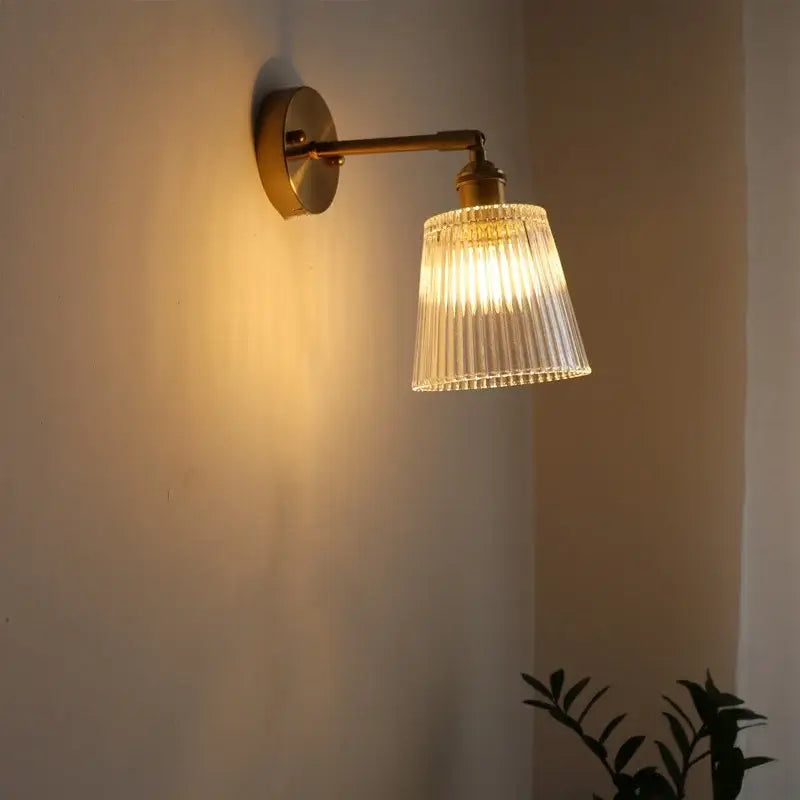 Brass-finished decorbites led glass wall light with fluted clear glass shade emitting warm light for modern decor