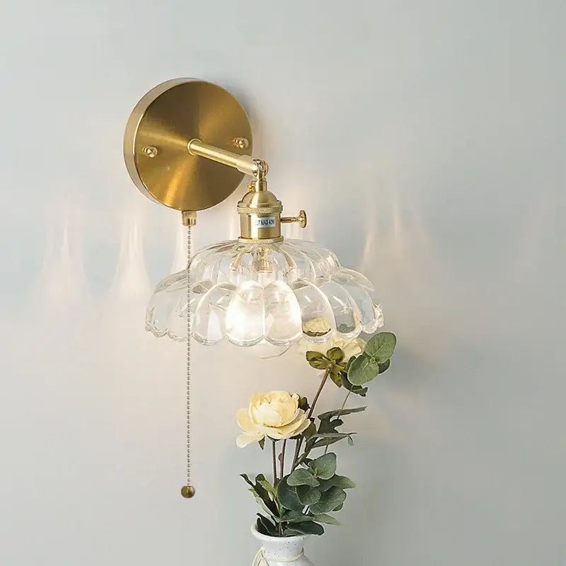 Gold-toned decorbites led glass wall sconce with clear scalloped glass shade and adjustable arm for bedside lighting