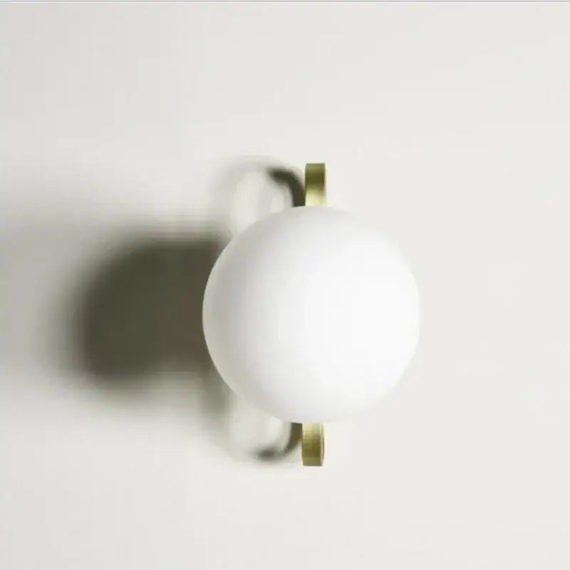 White spherical wall sconce with matte finish and brass brackets decorbites led glass wall fixture for modern home lighting