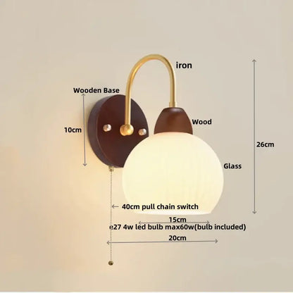 DecorBites led glass wall sconce with warm-toned glass globe brass arm dark wood base and pull chain switch