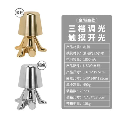 Gold-colored glossy resin decorbites led golden boy table lamp with inverted bell top and four stylized leg supports