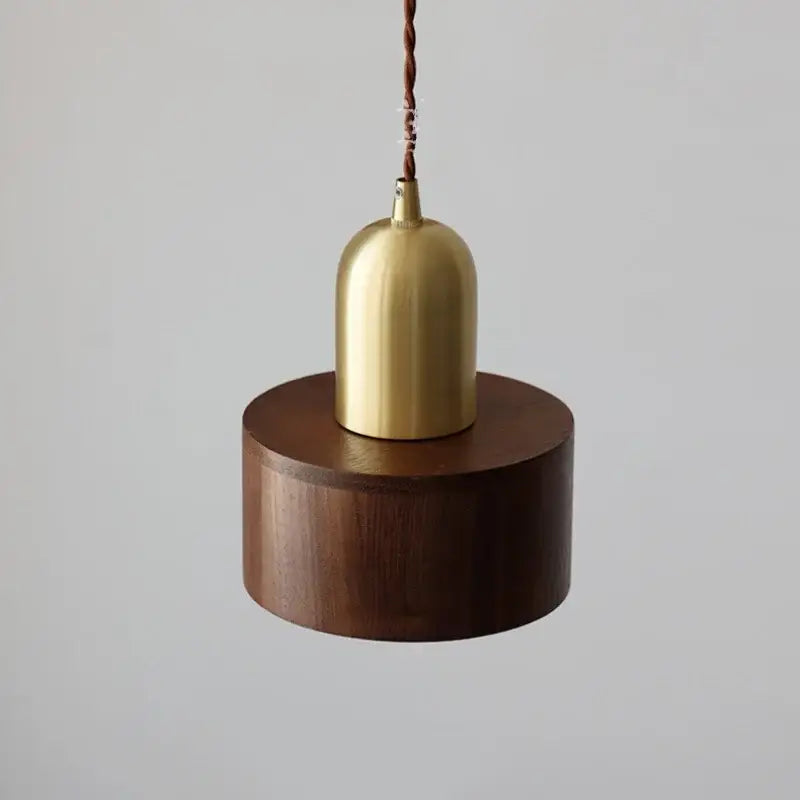 Decorbites led hanging lamp with polished brass cylindrical shade suspended by twisted brown cord above walnut base