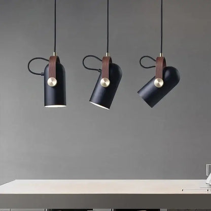 Three black cylindrical pendant lights with brown leather straps and brass accents from decorbites led hanging lamp collection