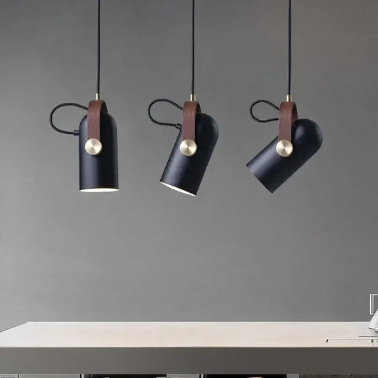 Three black cylindrical pendant lights with brown leather straps and brass accents from decorbites led hanging lamp collection