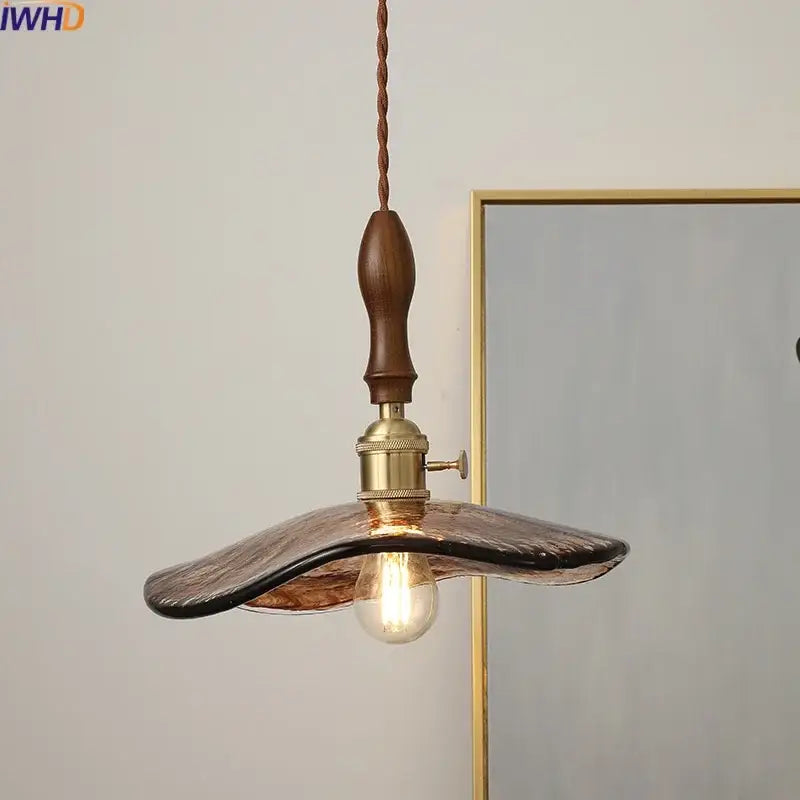 A warm-toned hand-blown glass decorbites led hanging light with bronze metal fixture and wooden handle for living rooms