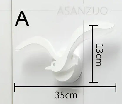 White ceramic wall-mounted bird sculpture 13cm tall 35cm wide paired with decorbites led jellyfish wall sconce light