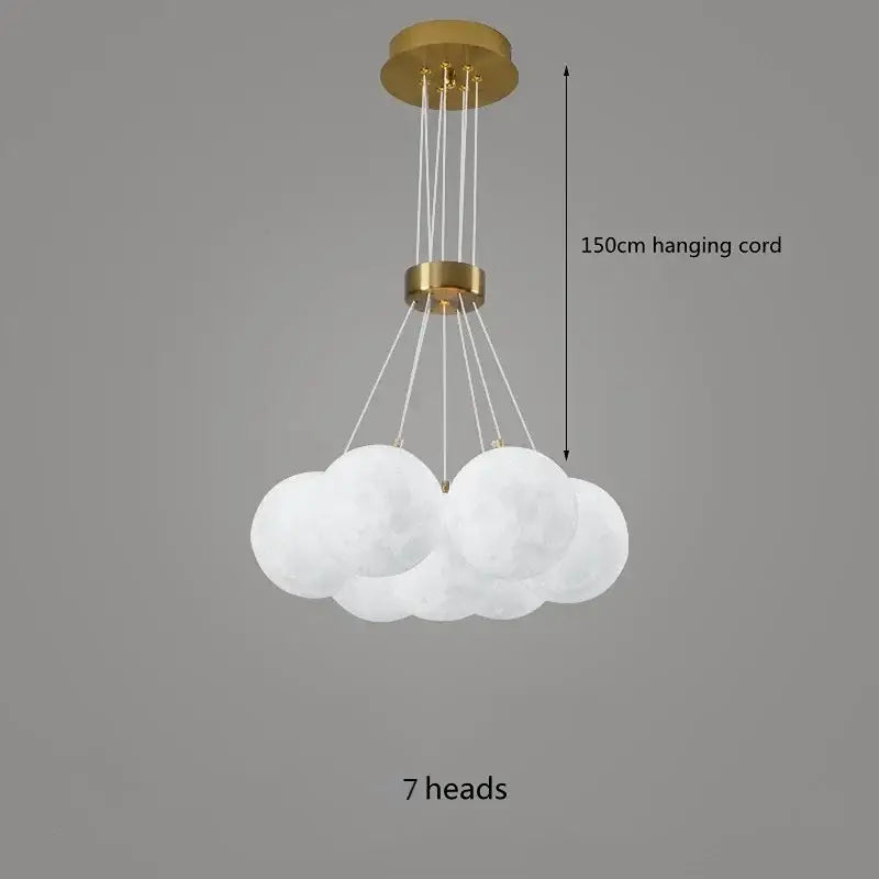 A modern decorbites led lunar cloud-shaped pendant light with seven frosted white spheres on a 150cm gold cord