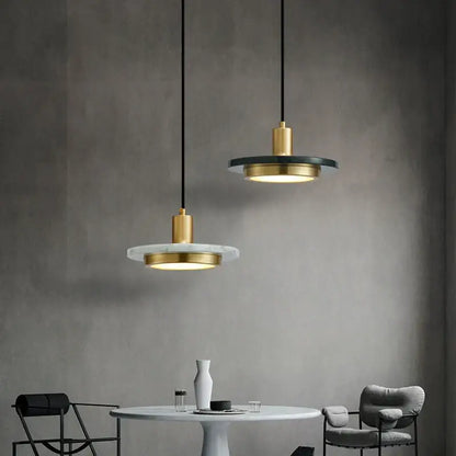Two modern DecorBites LED marble pendant lamps with gold metal fixtures and white and black circular marble plates