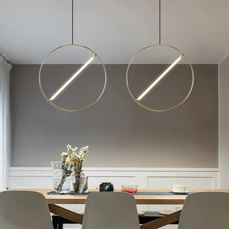 Two minimalist gold-toned decorbites led metal pendant lights with illuminated diagonal led strips for dining room use