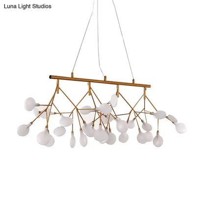 Gold-toned metal ceiling light with frosted glass globe shades in a tree branch design for minimalist dining room