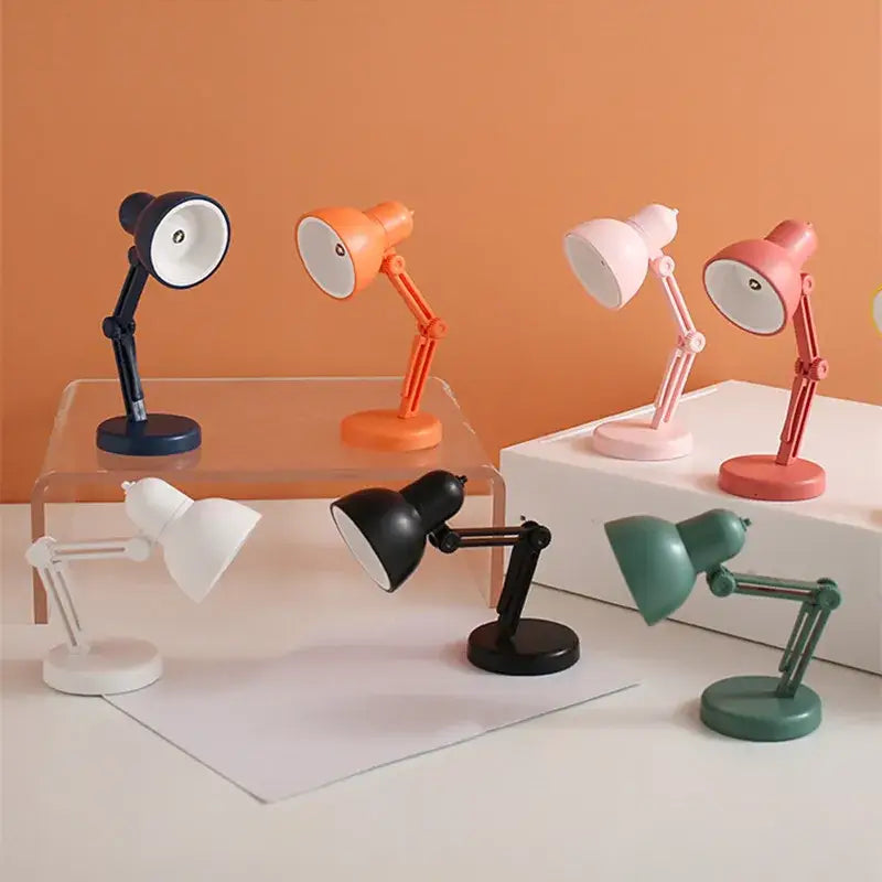 A collection of decorbites led mini desk lamps in navy blue orange pink white black and mint green with clip foldable design