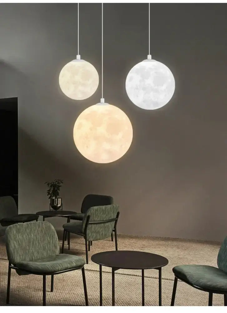 Three spherical pendant lights resembling moons with textured surfaces emitting soft white and warm yellow light in decorbites led moon planet ceiling chandelier