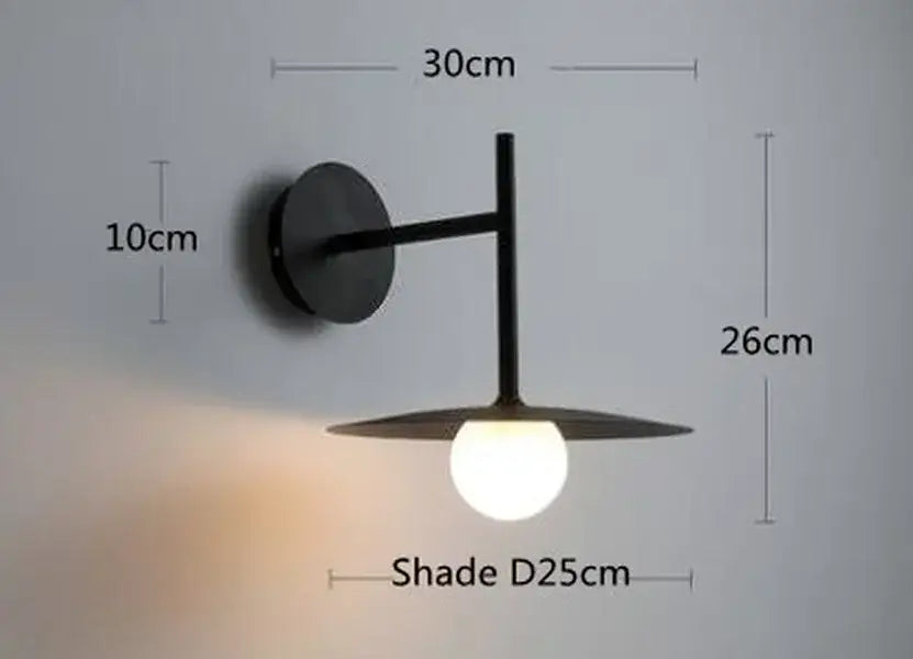 Black minimalist decorbites led movable wall lamp with sleek circular base and flat disc shade for bedroom lighting