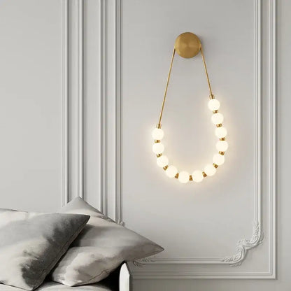 Gold-toned decorbites led necklace wall light with black metal base and glowing spherical led necklace wall bulbs for home use