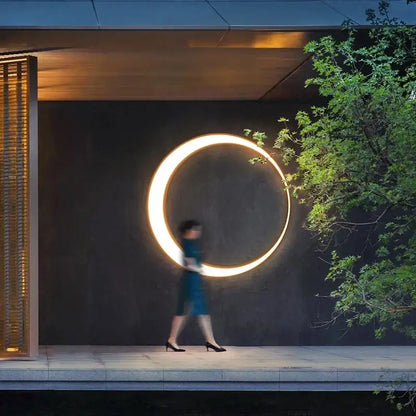 A decorbites led outdoor moon wall lamp emits warm golden light on a dark wall perfect for courtyard balcony use
