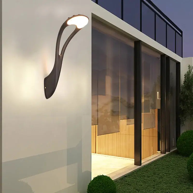 Modern black DecorBites™ outdoor wall lamp with sleek curved design and warm white LED light for garden and balcony