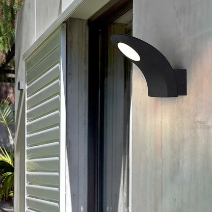 Black curved decorbites™ led outdoor wall lamp with bright white illuminated circular face and modern design