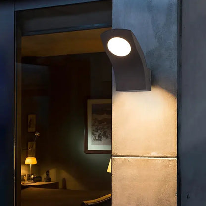 Modern black curved DecorBites™ LED outdoor wall lamp emitting warm circular light for garden balcony and courtyard use