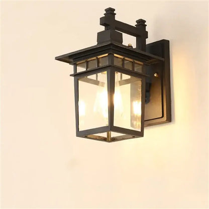 Black wrought iron decorbites led outdoor wall lamp with clear glass panels and warm glowing led light inside