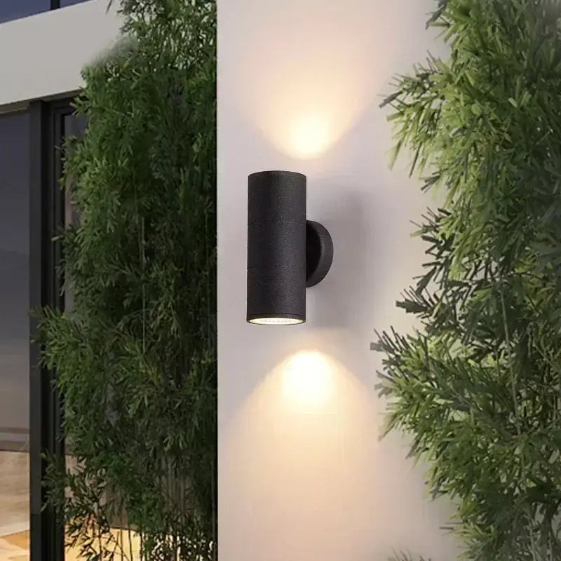 Black cylindrical decorbites™ led outdoor wall lamp with dual downward-facing lights for porch lighting