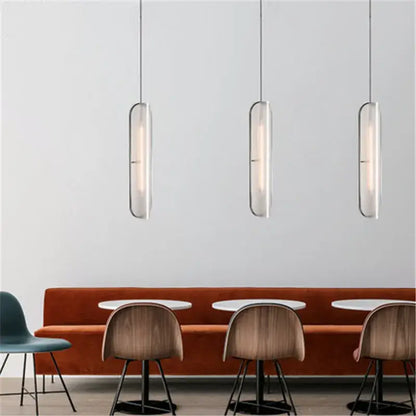Three sleek frosted glass decorbites led pendant lamps with metallic frames hang in a modern dining space