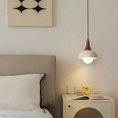 A decorbites led pendant lamp featuring a matte white glass dome shade and slender brown metal stem for bedside use