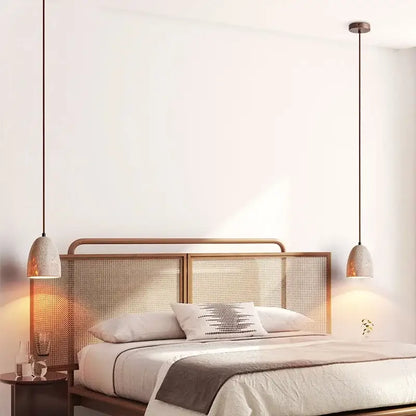 Two decorbites led pendant lamps with textured off-white ceramic shades and dark metal cords in japanese style