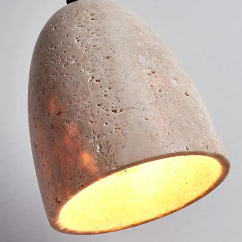 DecorBites led pendant lamp featuring a textured light gray concrete shade with warm yellow travertine interior glow