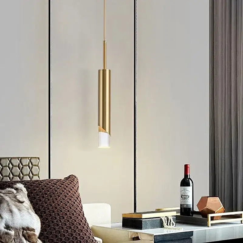 A sleek gold decorbites led pendant lamp with a cylindrical acrylic design for kitchen island and living room use
