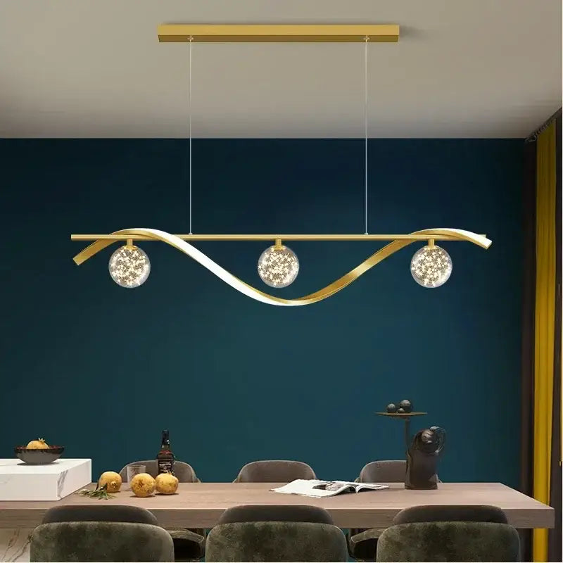 Gold-toned decorbites led pendant lamp with sleek curved design and three glass globes for dining room lighting