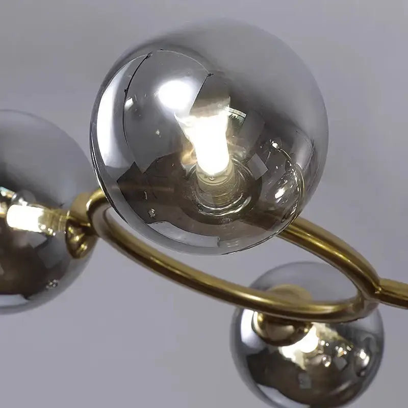 Modern chandelier with polished brass arms and reflective smoked glass spheres in DecorBites led pendant light for indoor lighting