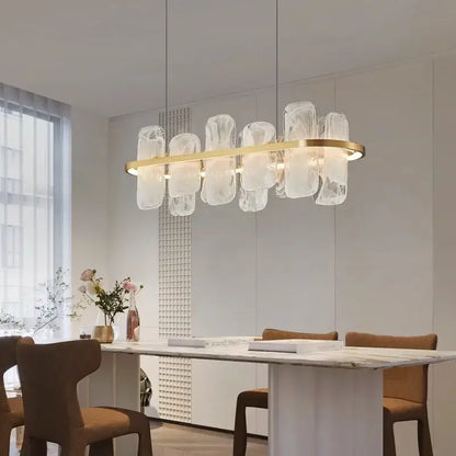A decorbites led pendant light chandelier with a gold circular frame and translucent glass elements above dining table