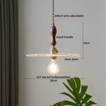 A decorbites led pendant light featuring a dark wood handle brass hardware and clear textured glass for modern lighting