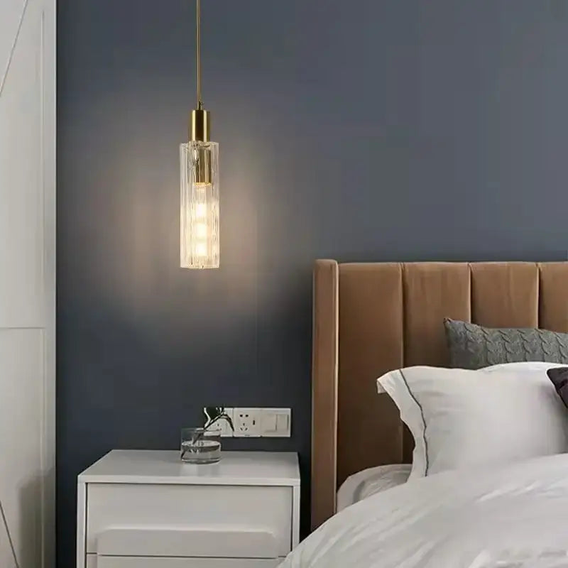 DecorBites™ LED pendant light features a gold-toned metal fixture and clear textured glass shade for modern bedside decor