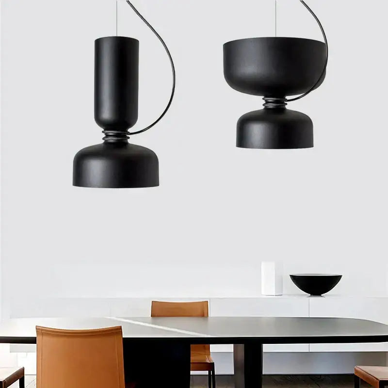 Two sleek black minimalist iron pendant lights from decorbites led pendant hang above a modern dining table
