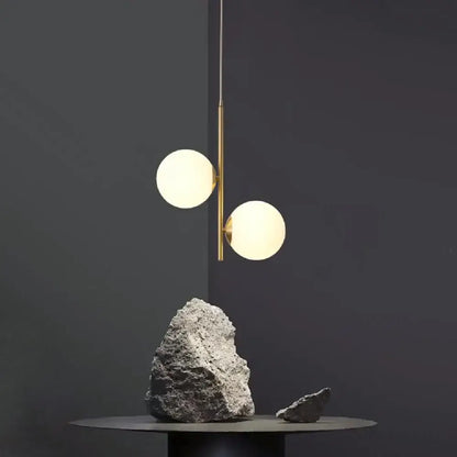 Modern brass decorbites led pendant light with two glowing spherical glass shades for home decor lighting