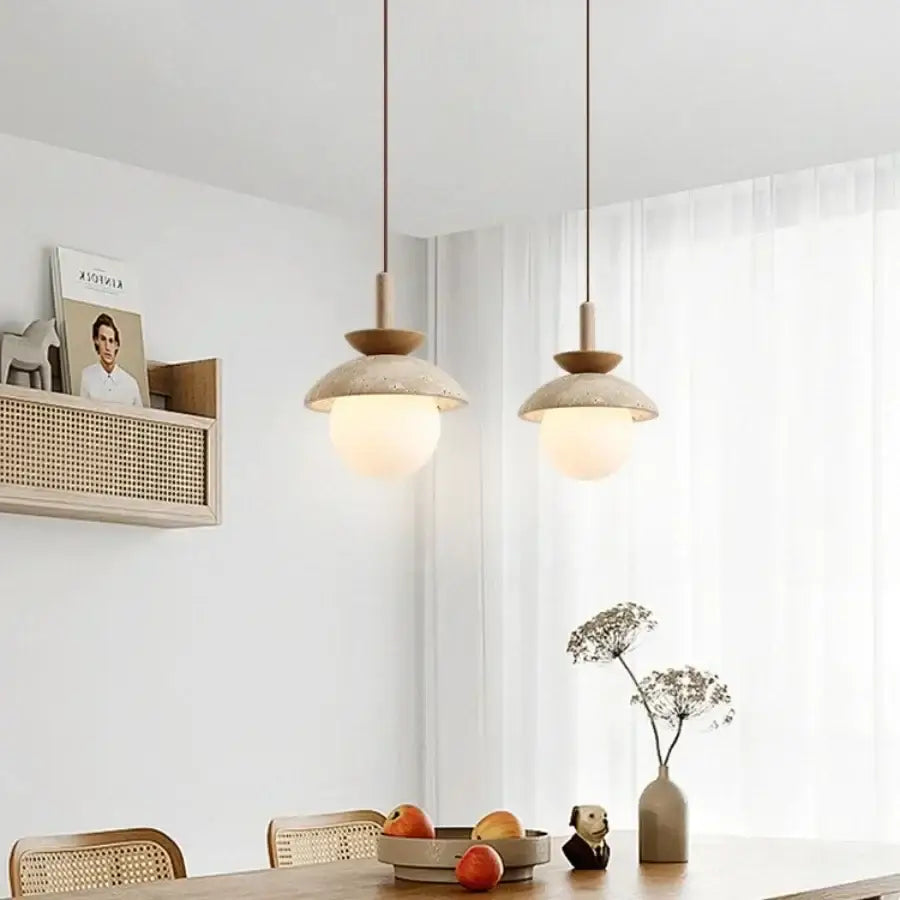 Two minimalist matte beige ceramic shades decorbites led pendant light with wooden accents above dining table