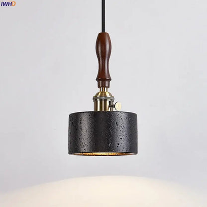 Black textured cylindrical pendant light with brass fixture and dark wood handle by decorbites led pendant light black travertine