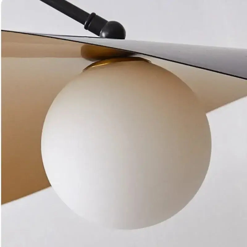 Cream-colored frosted glass globe pendant light with black metal arm and gold hardware from decorbites led pendant lights