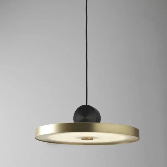 A modern decorbites led pendant light with a circular brass disc and matte black sphere for living room use