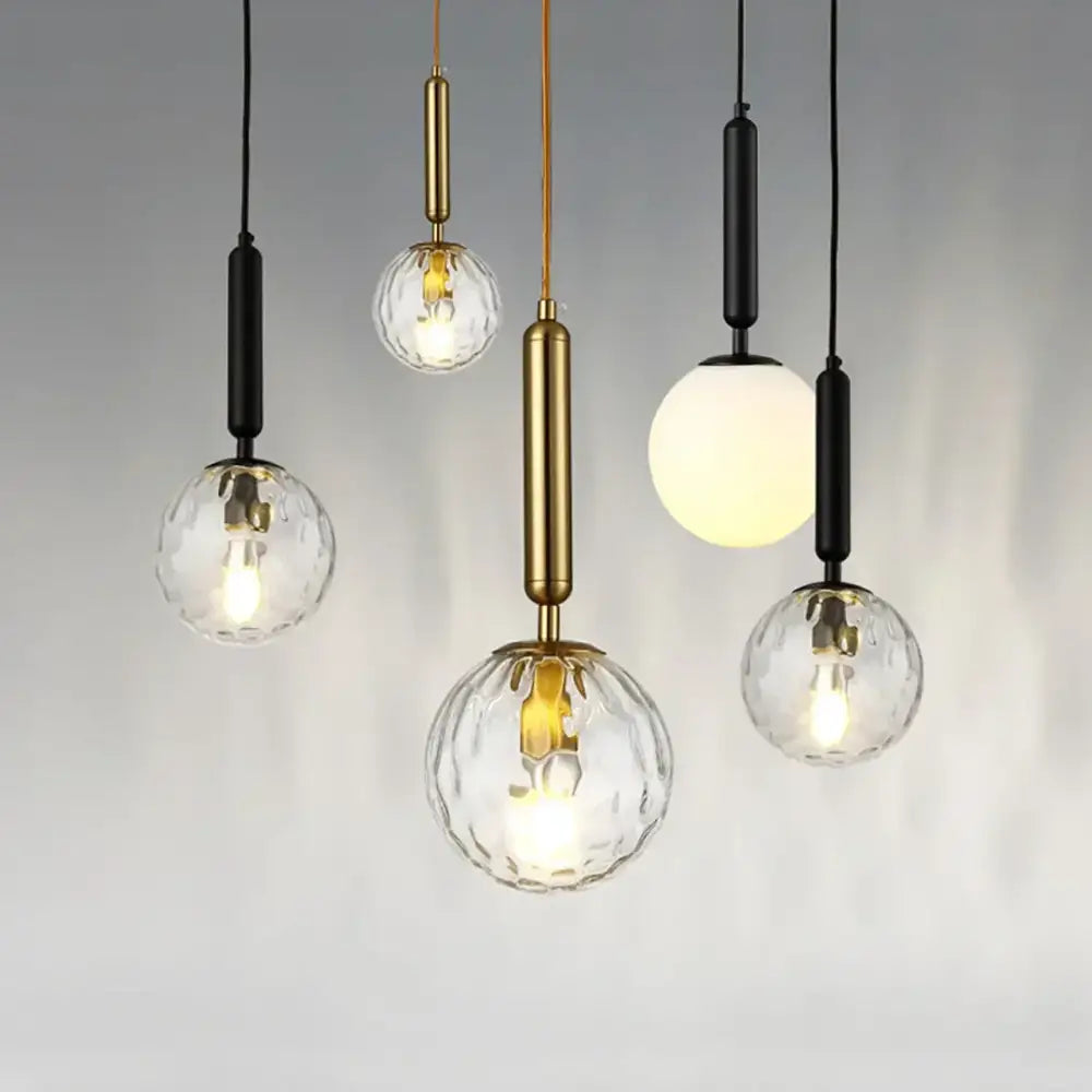 Modern decorbites led pendant lights with clear textured glass globes and brass or black metal fixtures for dining room
