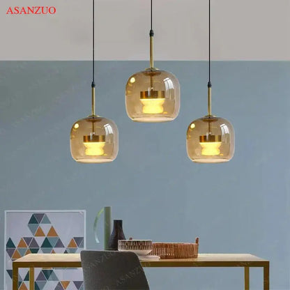 Three amber glass led pendant lights with brass accents hang from black cords by decorbites led pendant for home decor