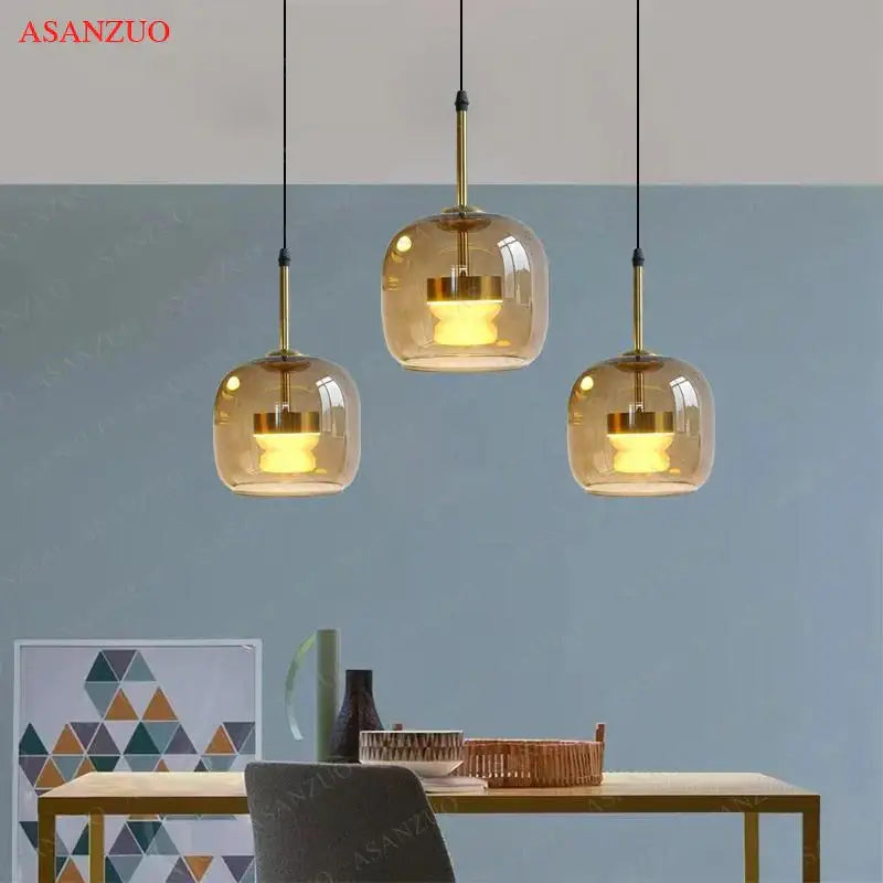 Three amber glass led pendant lights with brass accents hang from black cords by decorbites led pendant for home decor