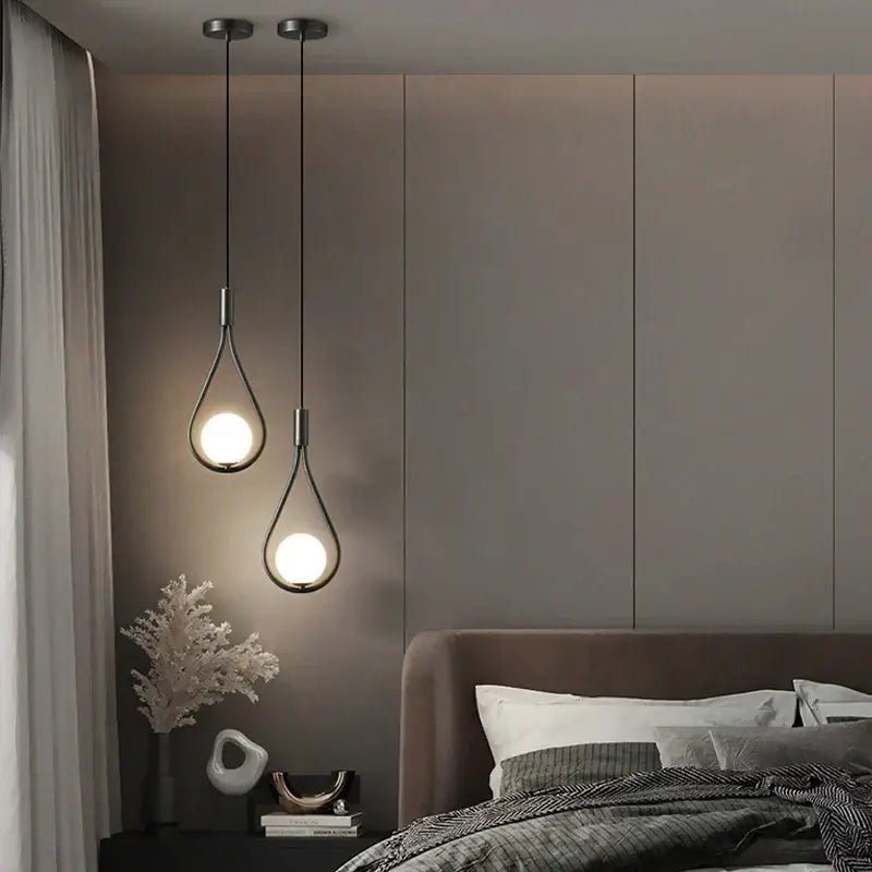 Two modern pendant lights with teardrop glass shades and black metal frames from DecorBites LED pendant lights