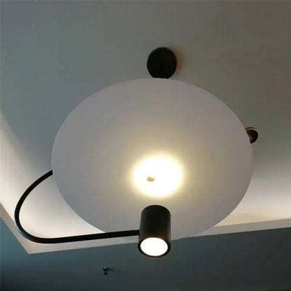 Modern minimalist pendant light fixture with frosted white spherical shade black metal arm and integrated spotlight by decorbites led