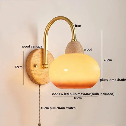 A warm-toned glass lampshade with brass iron arm and wooden canopy in decorbites led pull chain wall lights for bedroom decor