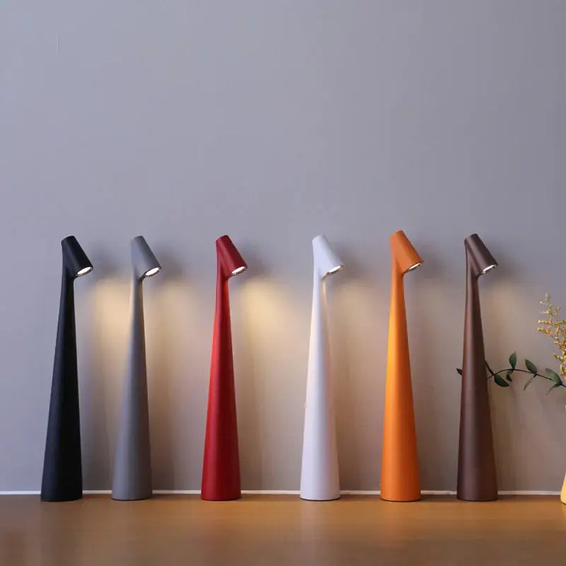 A sleek modern decorbites™ led rechargeable desk lamp with a tapered conical body and adjustable head for study use