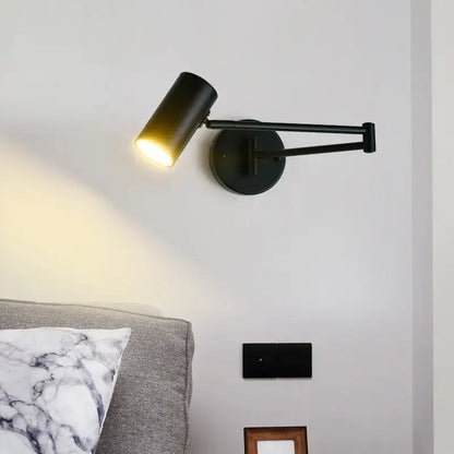 Black matte LED rotatable wall lamp with cylindrical gold-black metal sconce head emitting warm light